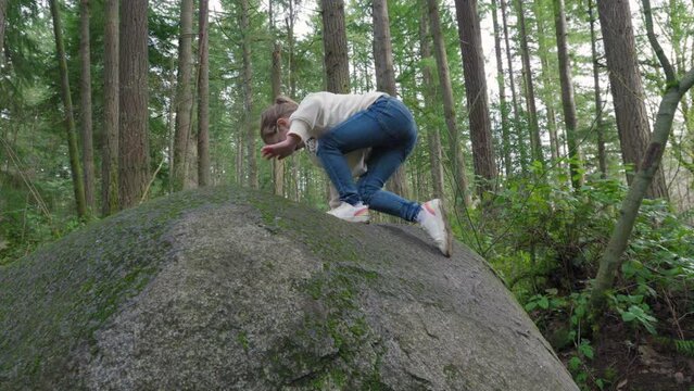 Adventurous Little Girls Climbing Rocks in the Woods