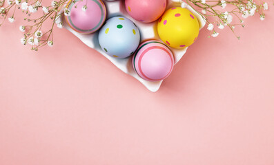 Colourful Easter eggs and gypsophila flowers background. Easter holiday composition with easter...