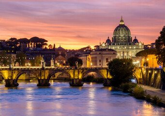 Fototapeta premium St. Peter's basilica dome and St. Angel bridge over Tiber river at sunset in Rome, Italy