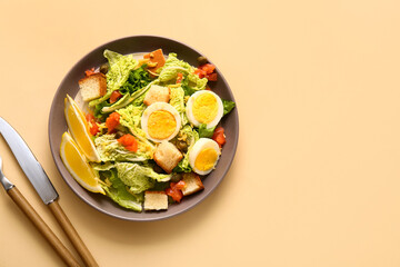 Plate of delicious salad with boiled eggs and salmon on beige background