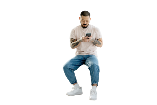 Serious handsome Korean man holding mobile phone shopping online isolated on transparent background. Young hipster guy with stylish tattoos on his hands chatting, reading text message. Clipping path  