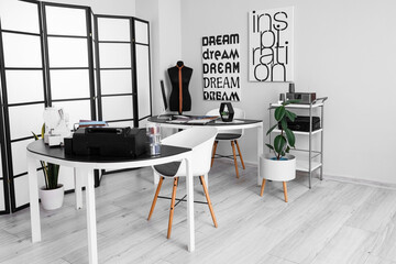 Interior of modern atelier with tables and mannequin