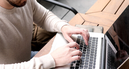 Close up hands multitasking man using laptop connecting wifi.