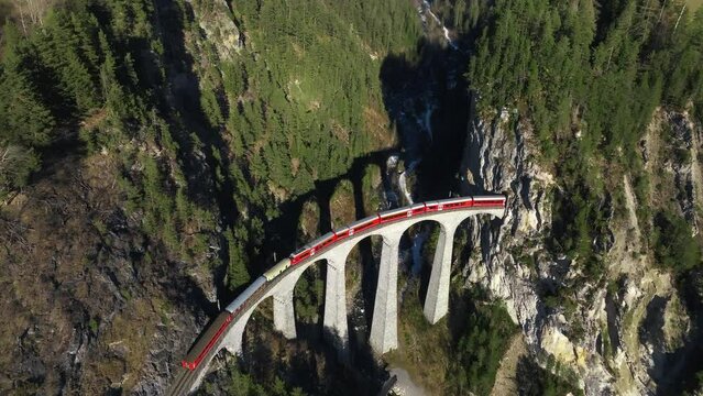 Aerial view of Train passing through famous mountain in Filisur, Switzerland. Landwasser Viaduct world heritage with train Glacier express in Swiss Alps.