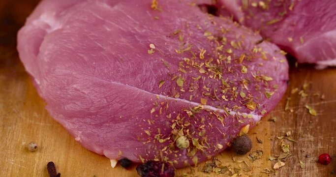 Pork sprinkled with spices and herbs during marinade meat, pickled meat with aromatic spices and herbs