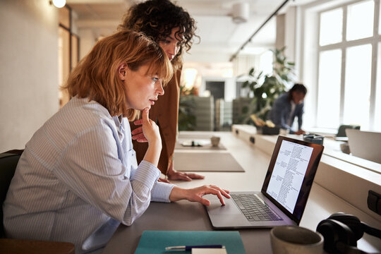 Businesswomen reading data on a laptop