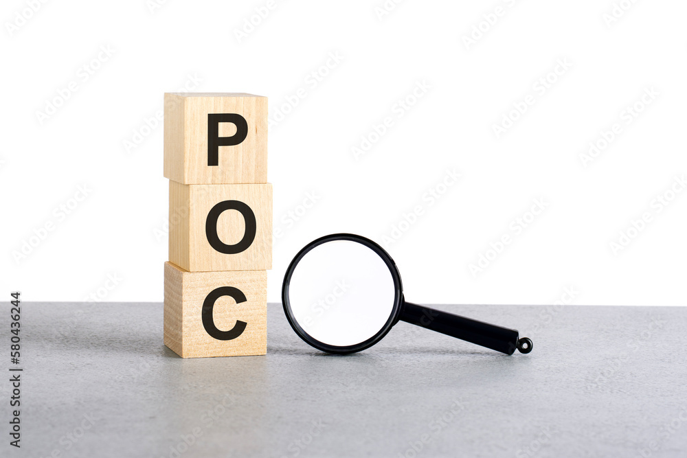 Poster poc - proof of concept - text wooden cube blocks and magnifying glass on grey table