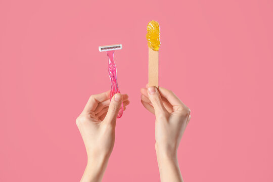 Hands holding spatula with sugaring paste and razor on pink background. Hair removal concept