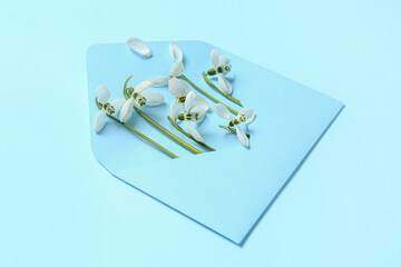 Envelope with beautiful snowdrops on blue background