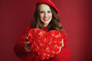 Closeup on happy trendy woman in red sweater and beret