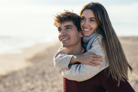 Beautiful young couple in love enjoying the day in a cold winter on the beach.