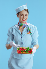smiling stylish flight attendant woman on blue