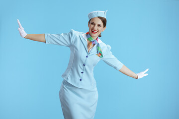 happy stylish flight attendant woman on blue