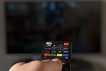TV remote controller with TV in background
