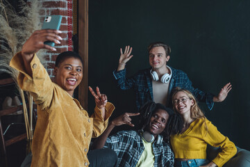 Fototapeta premium Cheerful group of diverse best friends taking selfie. Young people internation students have fun together, party, celebrate. African American, Caucasian multi cultural college university community