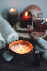 Concept of natural essential organic oils, Bali spa, beauty treatment, relax time. Atmosphere of relaxation, pleasure. Candles, towels, dark wooden background. Alternative oriental medicine