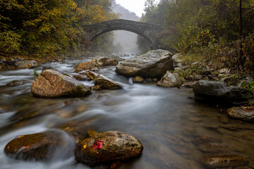 il torrente maira si insinua tra le rocce sotto il ponte del diavolo in una giornata d'autunno