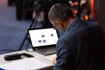 Selective focus of businessman in formal wear holding laptop during conference