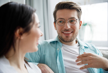 A man and a woman are chatting nicely sitting on the couch.