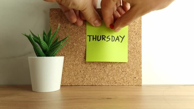 Paper note with word thursday on cork bulletin board. Happy thursday concept