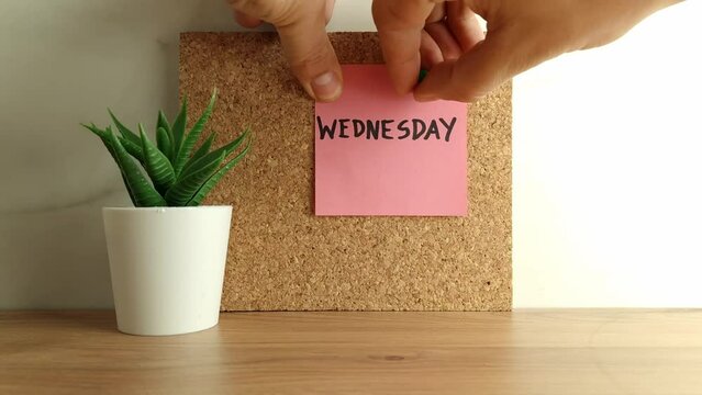 Paper note with word wednesday on cork bulletin board. Happy wednesday concept