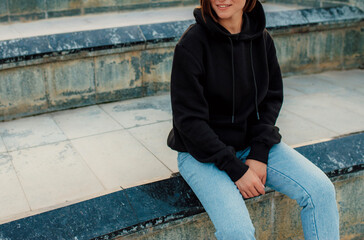 Handsome young female wearing black blank hoodie with space for your logo or design. Mockup for print