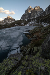 il monviso si specchia in uno spicchio del lago superiore ancora libero dal ghiaccio