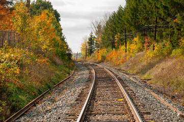 Fototapeta na wymiar A train track bending around a corner through a forest during autumn
