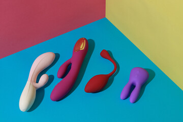 Adult sex toys such as dildo, vibrator, buttplug on colored background with shadows. Sexshop concept
