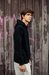 Collage of photos with handsome young guy wearing black blank hoodie with space for your logo or design. Mockup for print