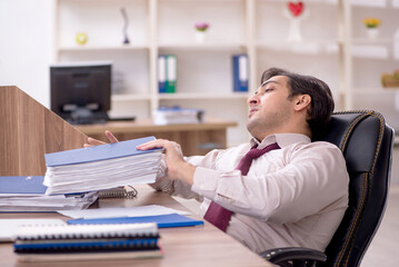Young male employee and too much work in the office