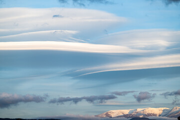 Panoramic view of large lenticular clouds over the snow-capped peaks of Sierra Nevada (Spain)