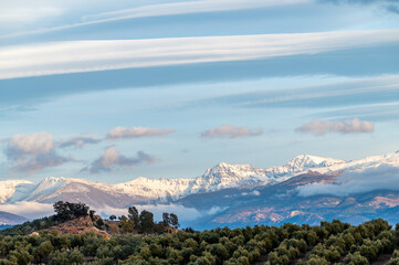 Panoramic view of large lenticular clouds over the snow-capped peaks of Sierra Nevada (Spain)