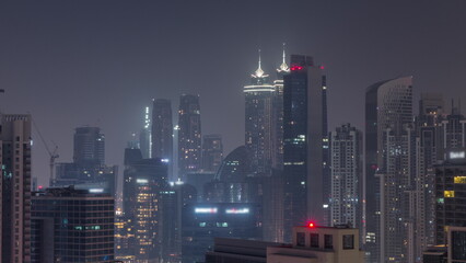 Dubai skyscrapers with illumination in business bay district during all night timelapse.