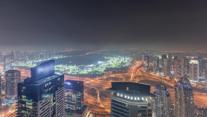 Obraz na płótnie Canvas Panorama of Dubai Marina with JLT skyscrapers and golf course night timelapse, Dubai, United Arab Emirates.