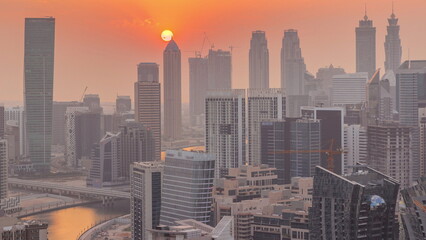 Skyline with modern architecture of Dubai business bay towers at sunset timelapse. Aerial view