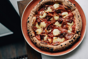 pizza with vegetables on a wood table with lives
