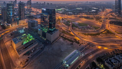 Fototapeta premium Aerial view of media city and al barsha heights district area night to day timelapse from Dubai marina.