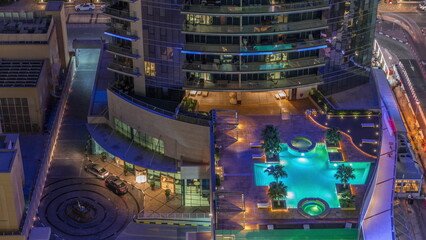Luxury outdoor swimming pool and relaxing zone around aerial night timelapse