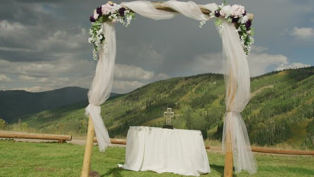 Push in on wedding alter and cross in Colorado mountains in summer in slow motion