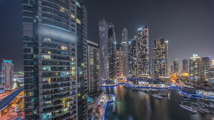 Obraz premium Dubai marina tallest skyscrapers and yachts in harbor aerial night timelapse.