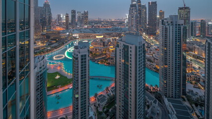 Obraz premium Dubai downtown with fountains and modern futuristic architecture aerial night to day timelapse