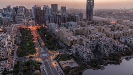 Skyscrapers in Barsha Heights district and low rise buildings in Greens district aerial night to day timelapse.