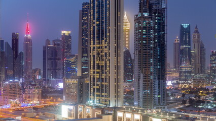 Naklejka na ściany i meble Row of the tall buildings around Sheikh Zayed Road and DIFC district aerial day to night timelapse in Dubai
