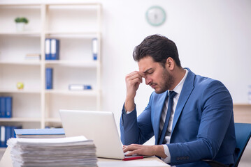 Fototapeta premium Young male employee and too much work in the office