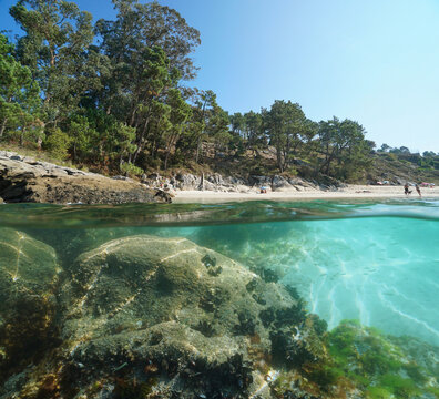 Beach in summer on the Atlantic coast in Spain, Galicia, split level view over and under water surface, Rias Baixas, Cangas de Morrazo