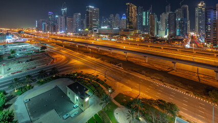 Dubai Marina skyscrapers and Sheikh Zayed road with metro railway aerial all night timelapse, United Arab Emirates