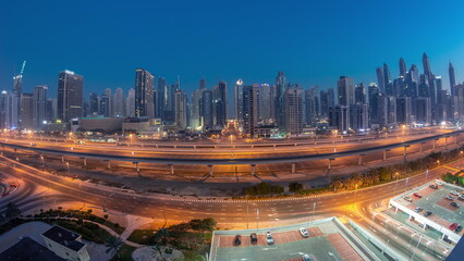 Panoraama of Dubai Marina skyscrapers and Sheikh Zayed road with metro railway aerial night to day timelapse, United Arab Emirates