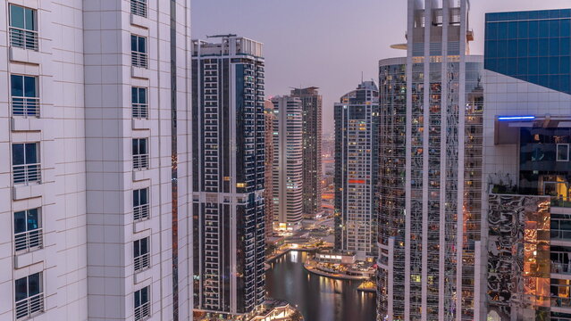 Tall residential buildings at JLT aerial day to night timelapse, part of the Dubai multi commodities centre mixed-use district.