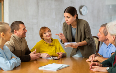 Young female teacher explaining subject to mature students